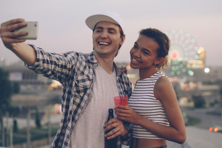 Dwie osoby robiące selfie z drinkami na dachu